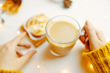 Coffee and cake with cream on the table. Female drinking latte and eating cake.