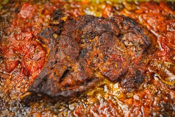 Obraz na płótnie Canvas meat with tomato baked in the oven, close-up view