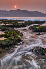 Fototapeta premium Beautiful view of the beach in sunsets with waves as leading line, Indonesia