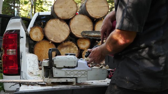 Opening the gas cap and filling a chainsaw with fuel.