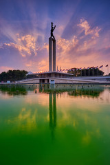 West Irian Liberation Monument in Jakarta under beautiful sky in the sunset with ray of light and reflection