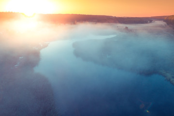 Early misty morning. Sunrise over the lake. Rural landscape in summer. Aerial view