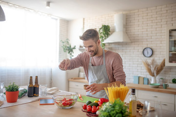 Smiling businessman enjoying weekend cooking at home