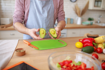 Close up of husband cooking avocado salad for dinner