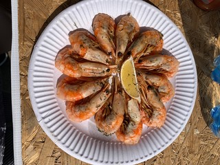 Shrimps with the lemon on the white plate
