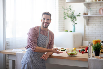 Husband welcoming his wife in the kitchen after cooking salad