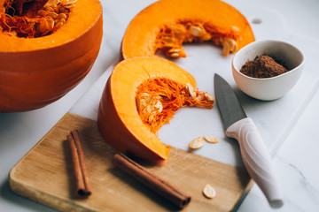 pumpkins with cinnamon sticks on marble backgrund