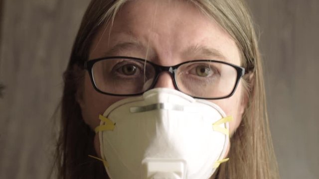 Head shot of woman wearing disposable dust mask