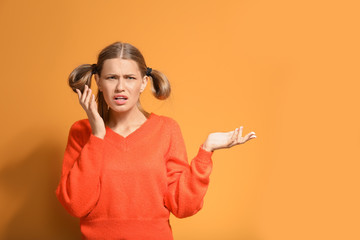 Indignant young woman on color background