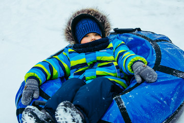 little kid in snow tube. winter time