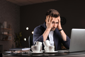 Tired man trying to meet deadline in office