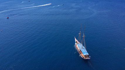 Tourists tour on old style pirate ship on calm clear drak blue sea Aerial