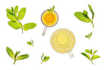 Glass of mint tea with fresh leaves and  a bowl of honey.  Flat layed and isolated on a white background,.