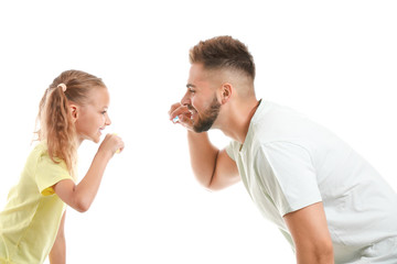 Portrait of father and his little daughter brushing teeth on white background