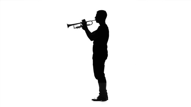 Professional musician playing on trumpet in slow motion. Black silhouette