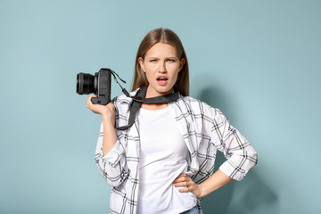 Beautiful female photographer on color background