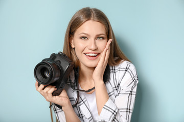 Surprised female photographer on color background