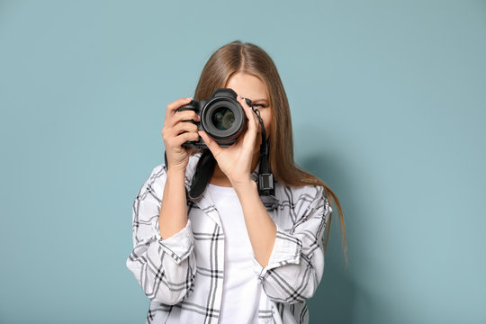 Beautiful female photographer on color background