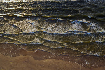 Baltic sea waves on sandy beach in evening.