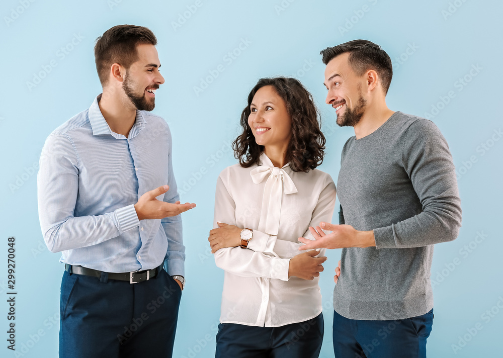 Wall mural Portrait of young business people on color background