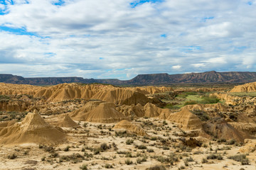 Fototapeta na wymiar Eroded hills and canyons in the white ground of the Spanish semi-desert Bardenas Reales