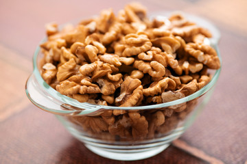 Studio photo of bowl with heap of peeled walnuts