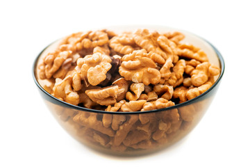 Studio photo of bowl with heap of peeled walnuts isolated on white