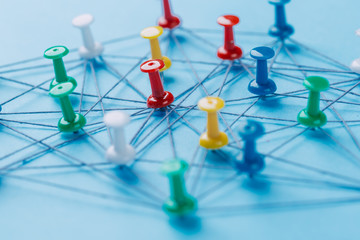 Small network of colorful pins and string, An arrangement of colorful pins linked together with...