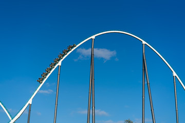 Roller coaster with train full of people in theme park
