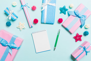 Top view of notebook on blue background made of Christmas decorations. New Year time concept