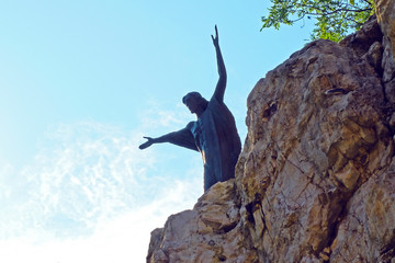 Jesus statue on top of hill with arms raised