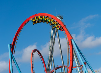 Roller coaster with train full of people in theme park