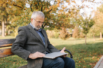 Grandfather close laptop after work in the park