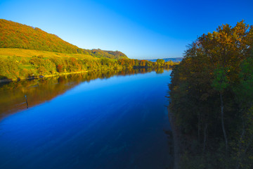 The river Rhine, only a few hundred meters young, after leaving Lake Constance. Autumn. Near the Swiss town Stein am Rhein. View from the car bridge to the west, the road leads to the Rhine Falls.