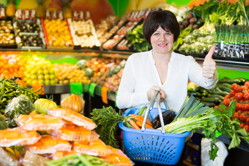 Adult female taking vegetables with basket