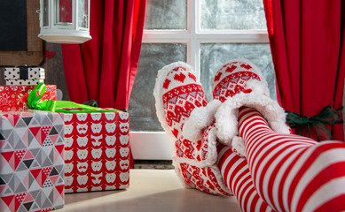 Fototapeta na wymiar Woman legs with socks on table and background of window, Christmas concept