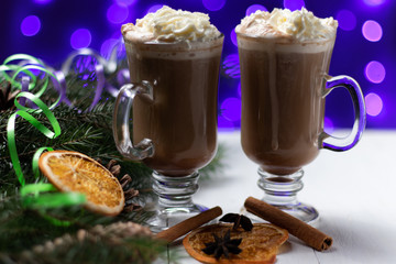 two cups of cappuccino with cream of cocoa winter new year fir tree cones bokeh blur holiday lights