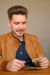 Young guy makes cigarette with hand rolling tobacco