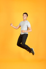 Fototapeta na wymiar Handsome jumping Asian man on color background
