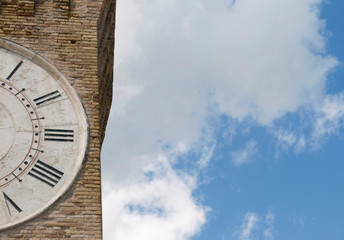 part of an ancient clock tower against the sky, Italy