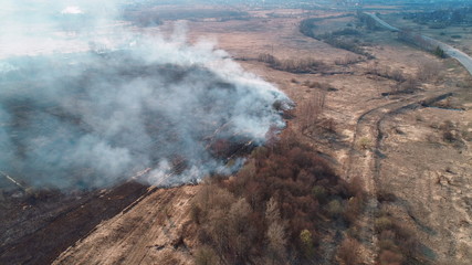Fototapeta na wymiar Forest and field fire. Dry grass burns, natural disaster. Aerial view.