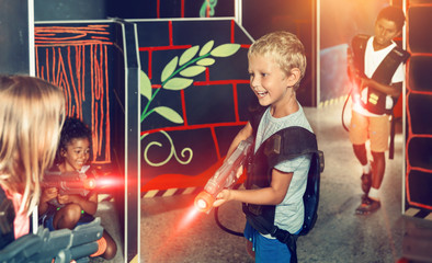 Fototapeta na wymiar Preteen boy with laser pistol playing on labyrinth