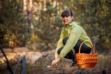 Beautiful girl in the autumn forest to gather mushrooms. Stay in the fresh air.