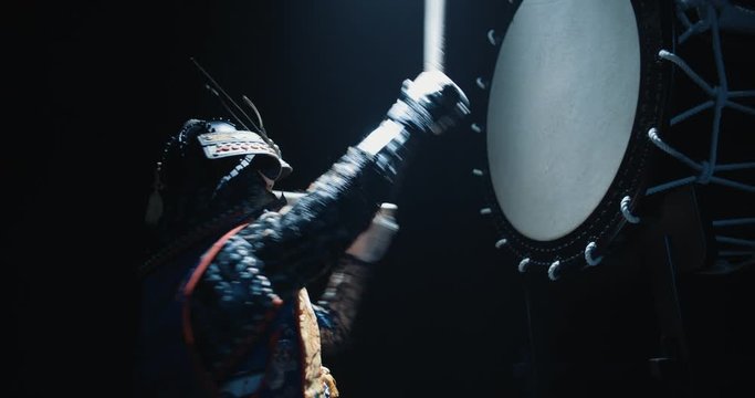 Asian man in historical samurai costume playing taiko drum, isolated on black background - tradition, history, culture concept close up 4k footage