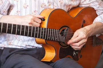 Fototapeta na wymiar Guitarist tunes vintage guitar