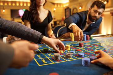 A group of people gamblers playing gambling poker roulette in a casino