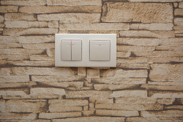 two white lighting switchs on concrete wall, on and off