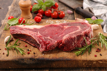 raw beef chop with ingredient on wooden background, rib of beef