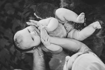hand leading child on water. black and white. mother happy little girl in pool. Teaches infant child to swim. Enjoy first day of swimming in water. Mom holds child preparing for diving. doing exercise