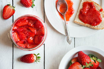 Homemade strawberry jam with fresh fruit on white